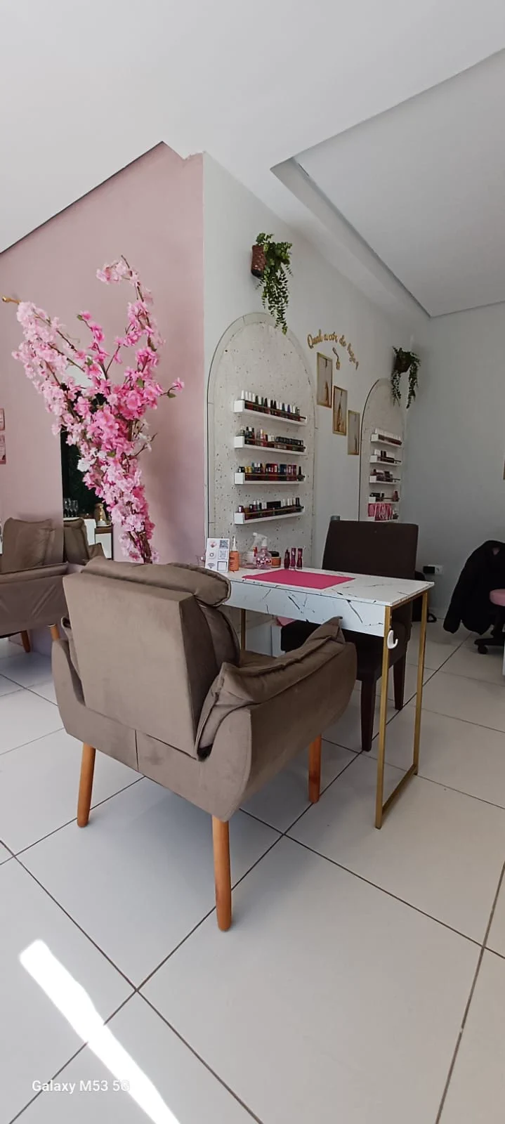 Estação de manicure com decoração floral e prateleiras de esmaltes